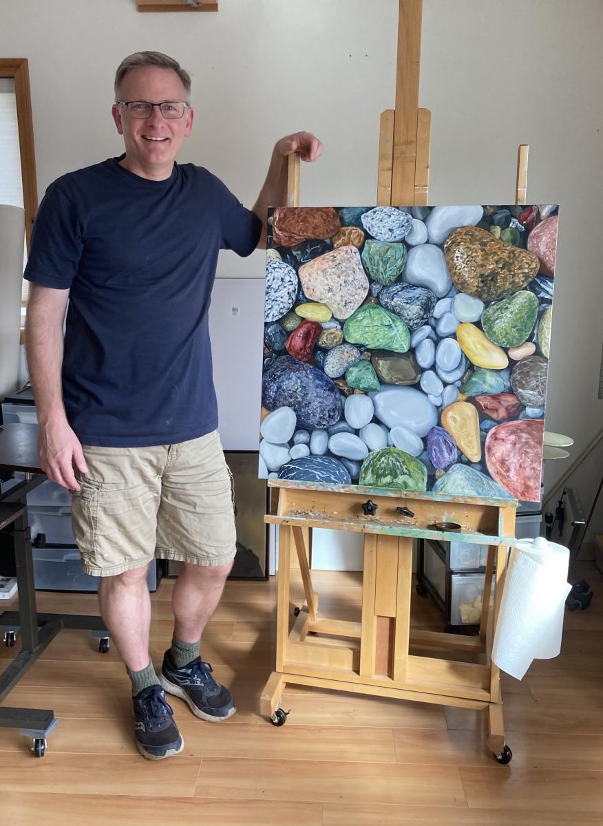 Tom Wheeler with painting of agates and rocks